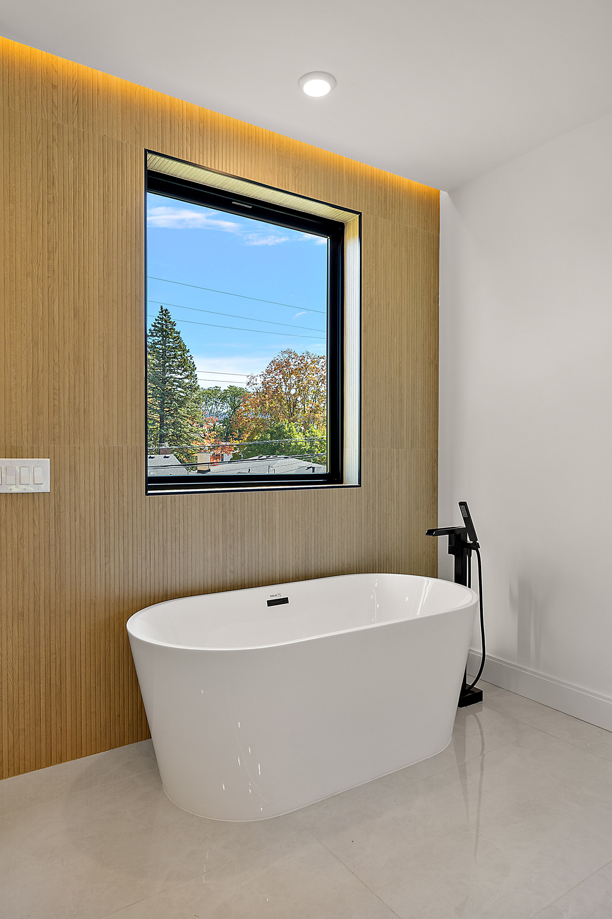 Master bath freestanding soaker tub with white oak slat wall
